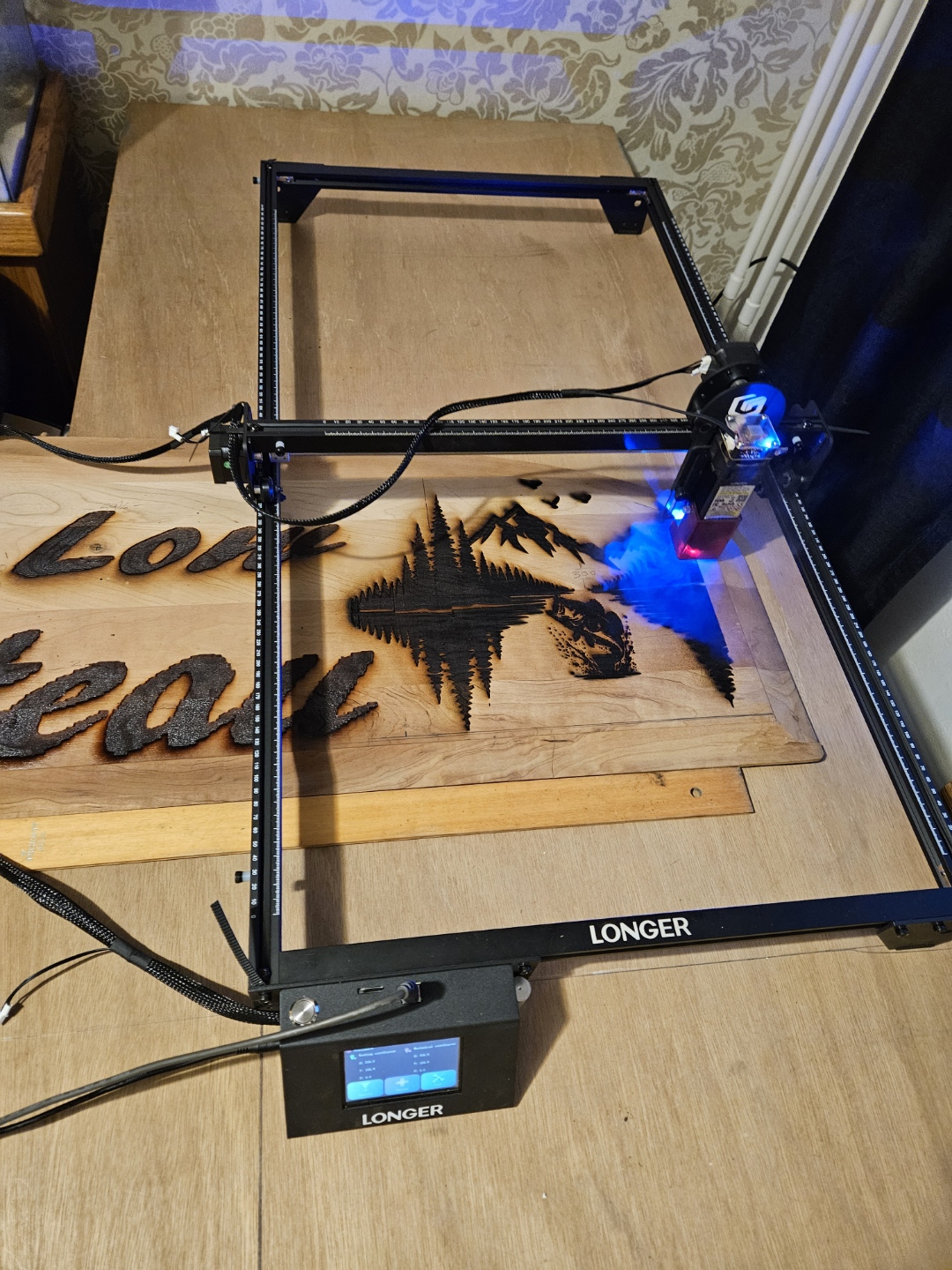 Laser engraving machine engraving a custom wooden sign